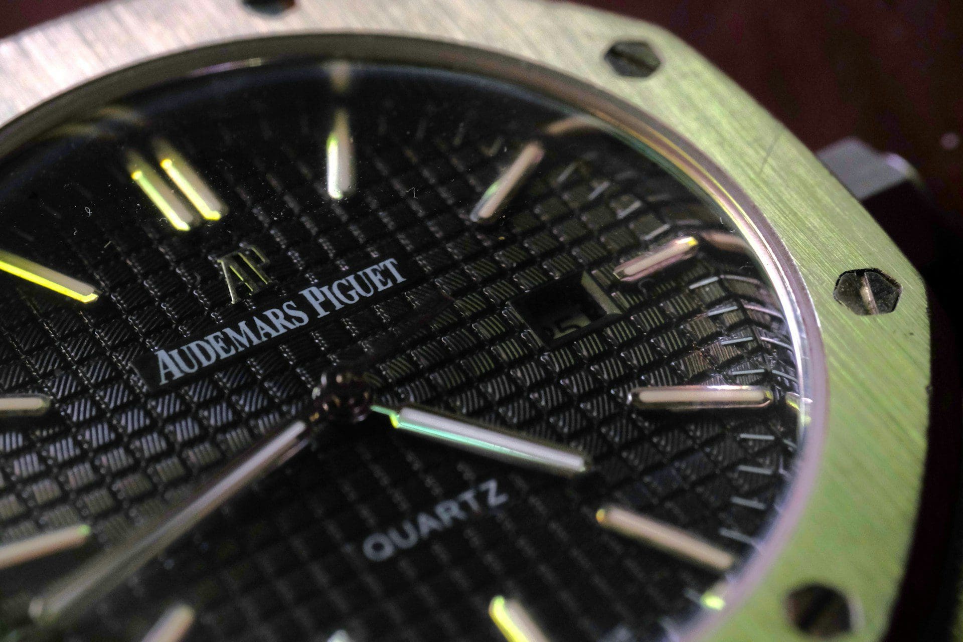 Close-up of an Audemars Piguet Royal Oak Quartz watch face with a black textured dial and silver hands.